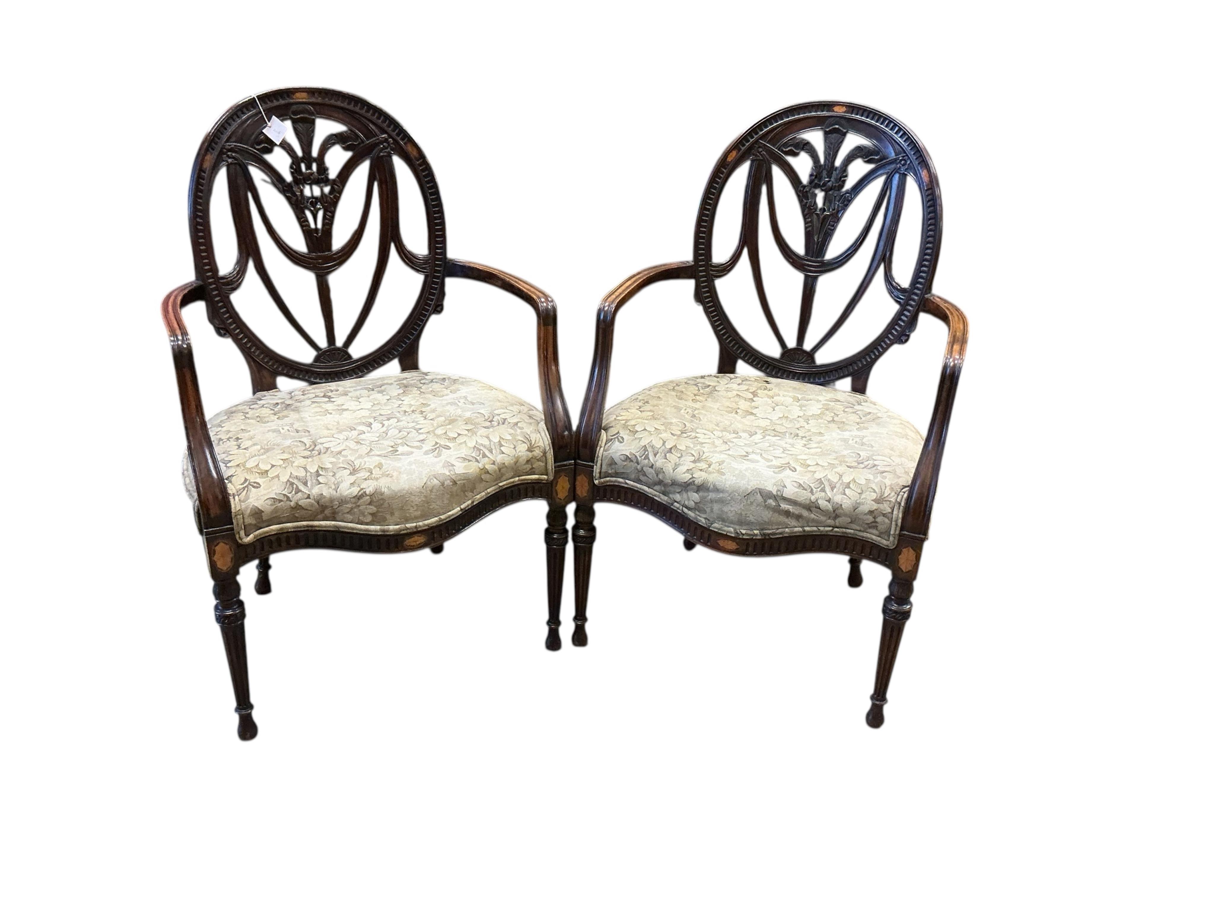 A pair of Sheraton style mahogany elbow chairs, with carved Prince of Wales splat backs, width 63cm, depth 52cm, height 102cm